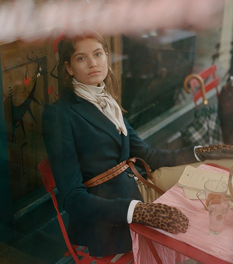 Woman wears riding blazer with leopard-print gloves and brown leather belt.